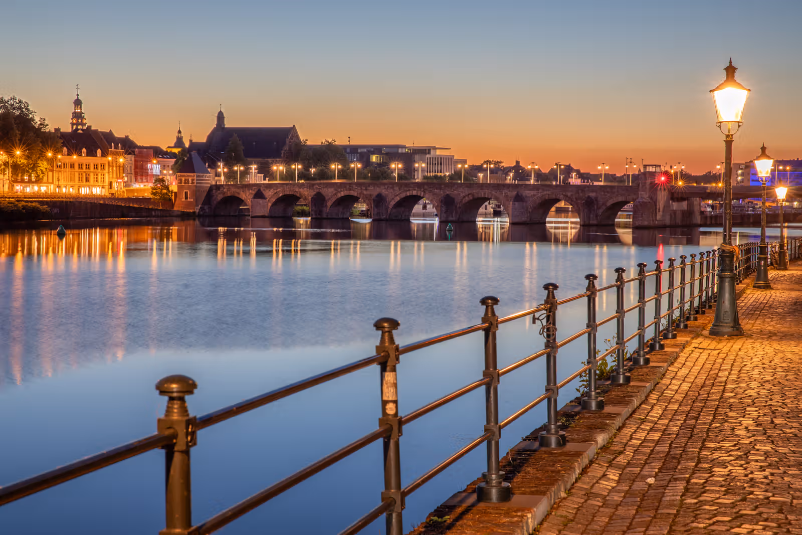 Kade en boogbrug bij zonsondergang