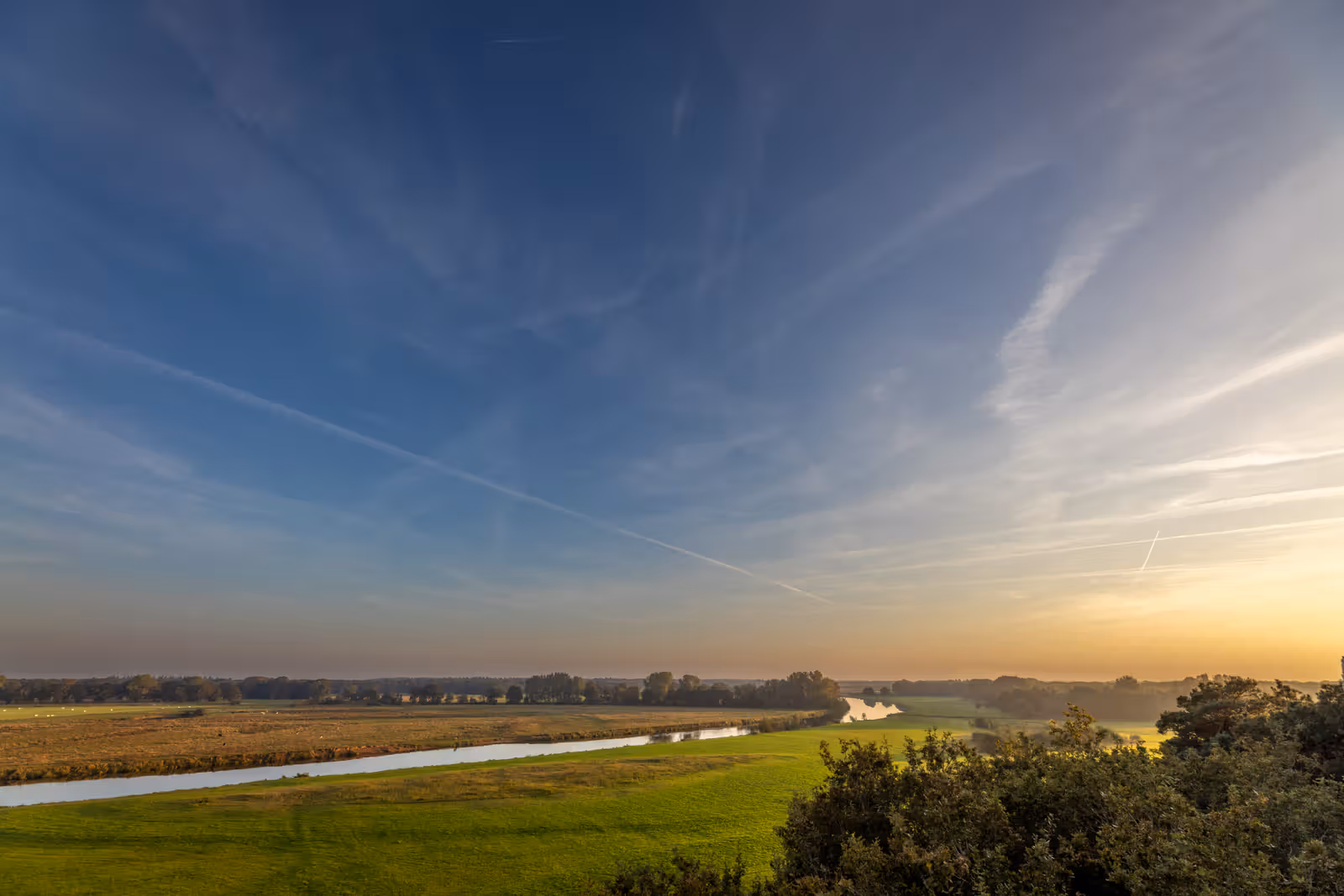 Meanderende rivier in avondlicht