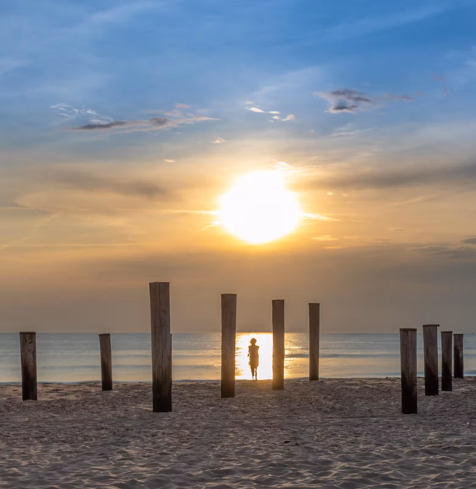 Zonsondergang met houten palen
