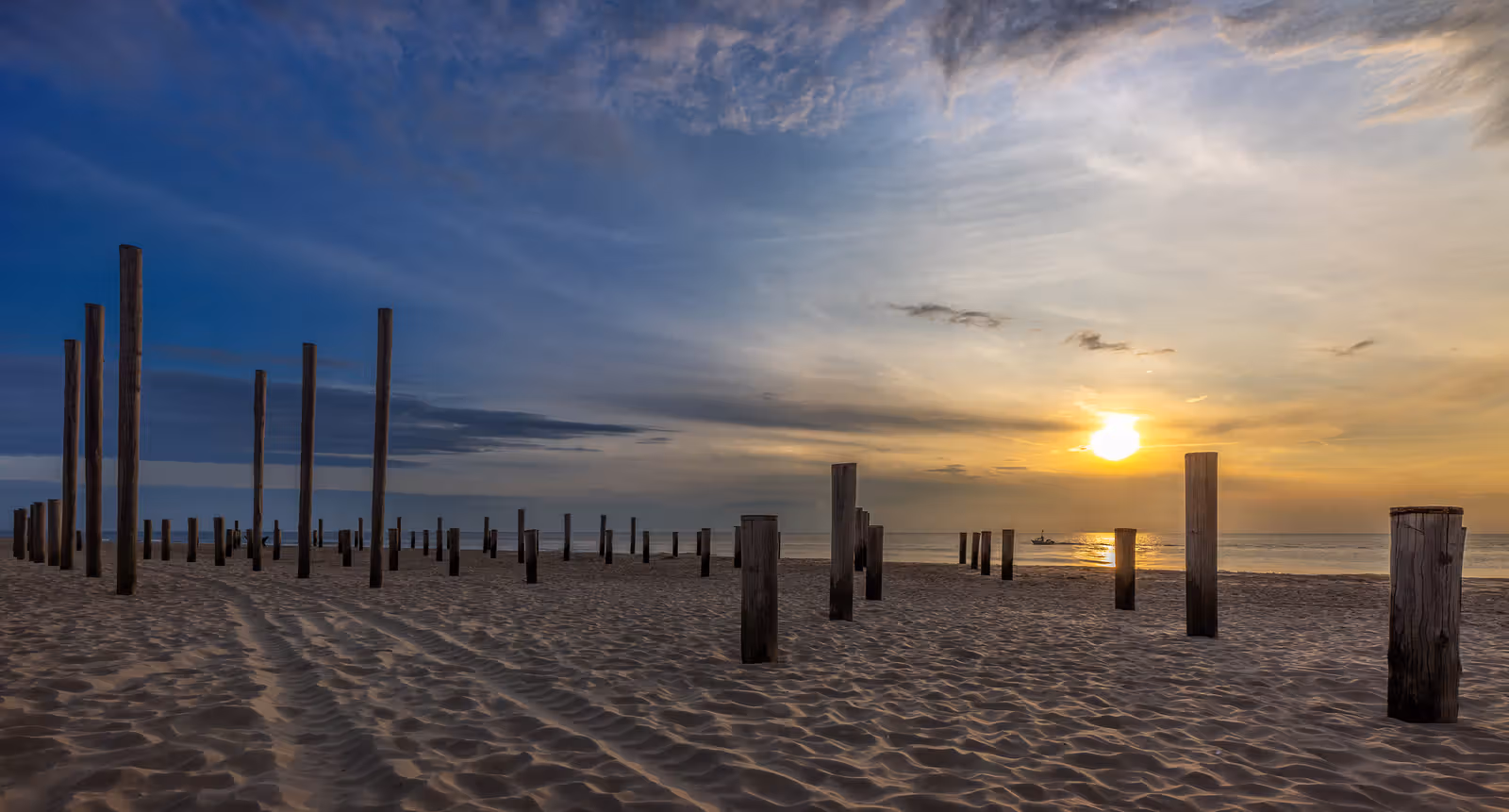 Strandpalen bij zonsondergang