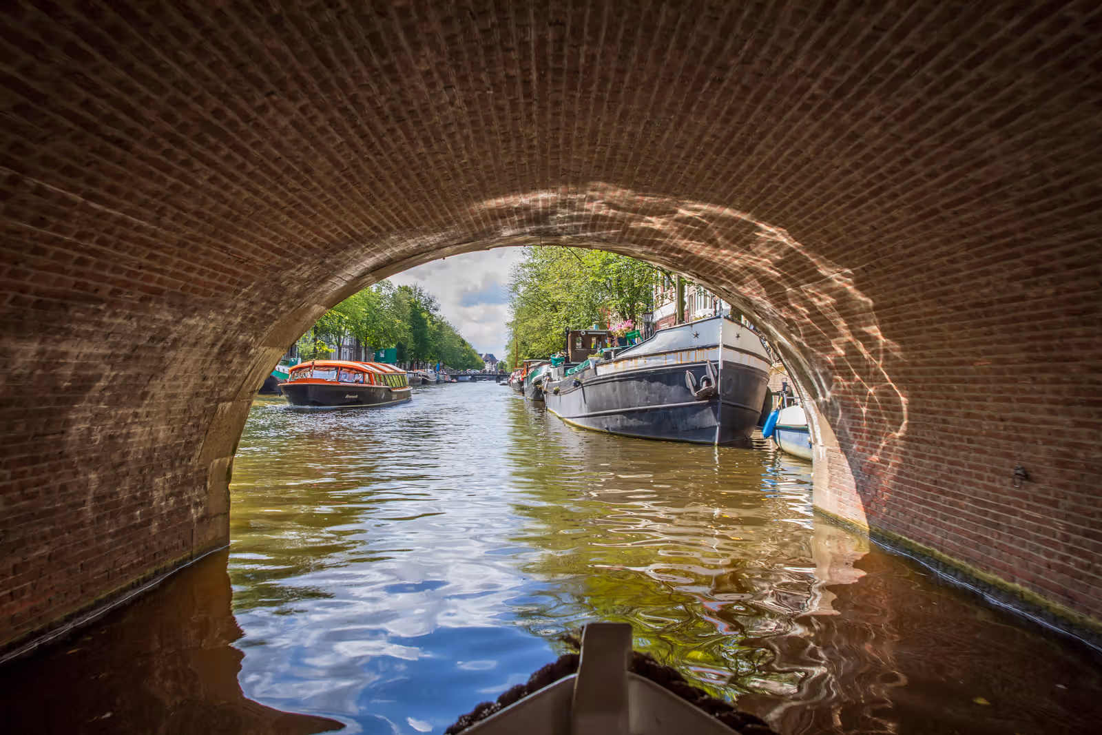 Grachtzicht onder bakstenen boog