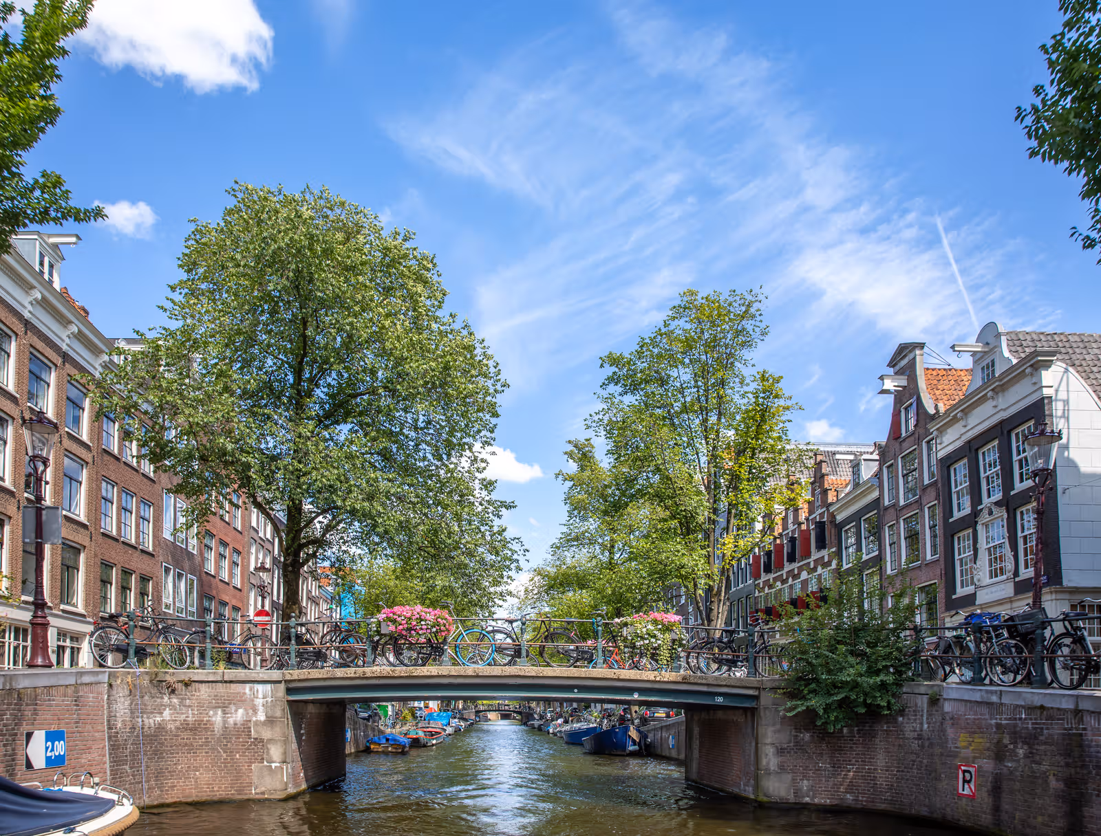 Brug over gracht met bloemen en fietsen